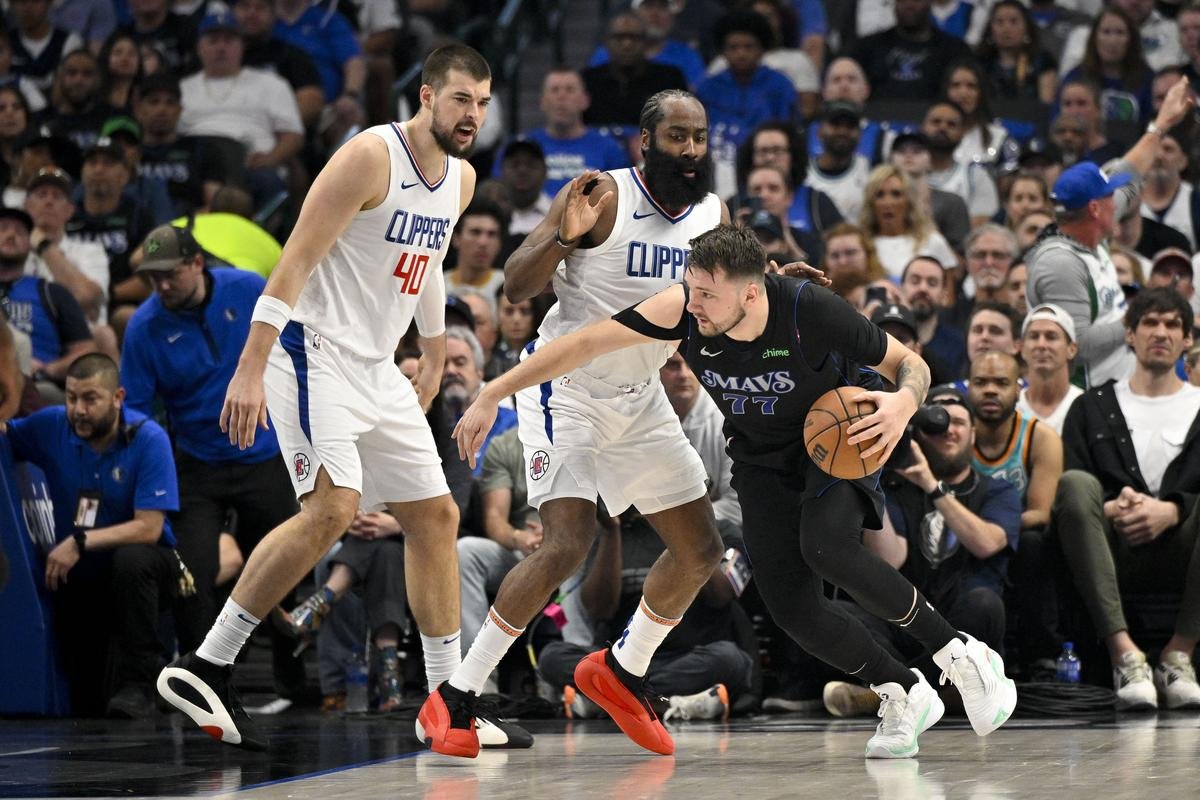 Dallas Mavericks guard Luka Doncic (77) looks to move the ball past LA Clippers guard James Harden (1) and center Ivica Zubac (40) during the first quarter during game six of the first round for the 2024 NBA playoffs.