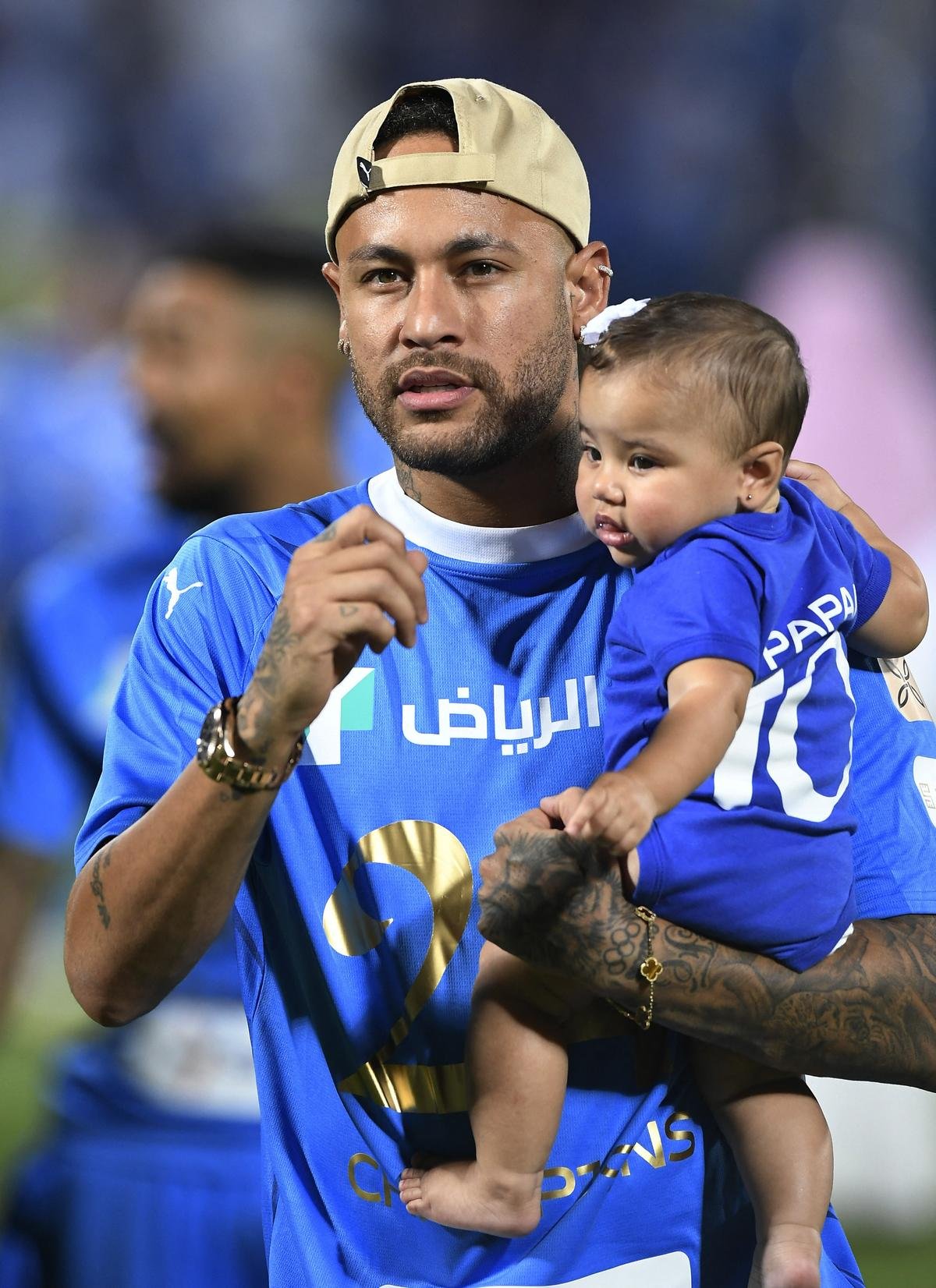 Neymar walks on the pitch holding his daughter Mavie after Al Hilal win the Saudi Pro League.
