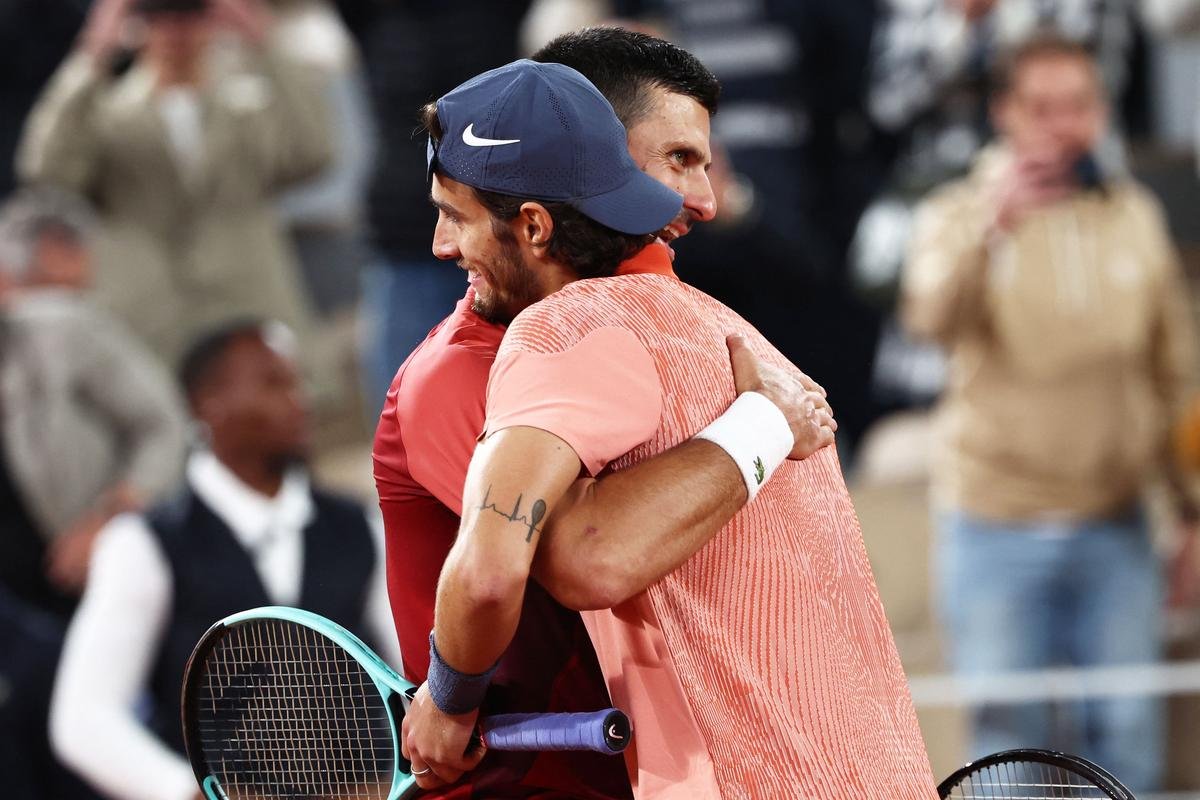 Serbia’s Novak Djokovic (L) with Italy’s Lorenzo Musetti after winning at the end of their men’s singles match. 