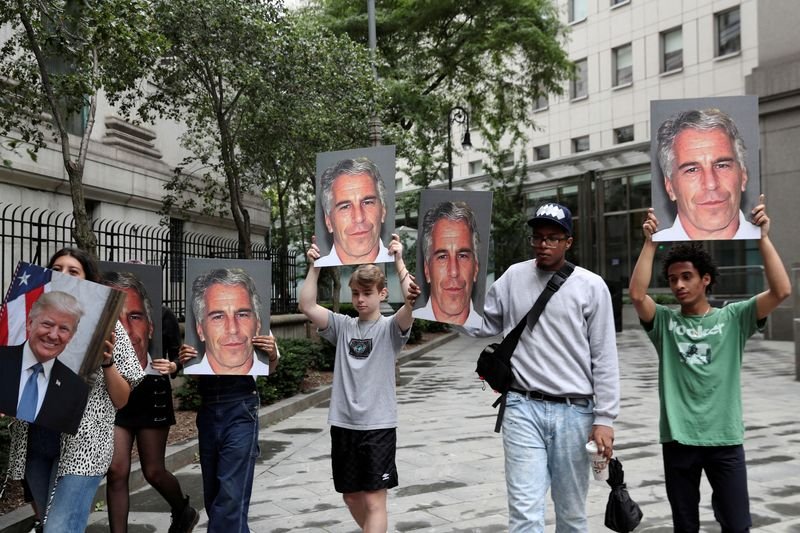 © Reuters. FILE PHOTO: Demonstrators hold signs aloft protesting Jeffrey Epstein, as he awaits arraignment in the Southern District of New York on charges of sex trafficking of minors and conspiracy to commit sex trafficking of minors, in New York, U.S., July 8, 2019. REUTERS/Shannon Stapleton/File Photo