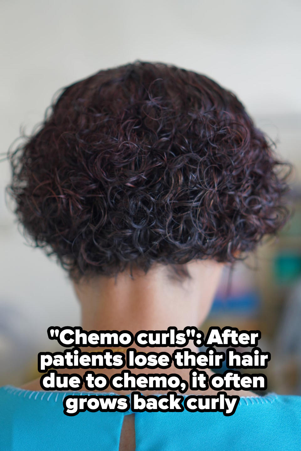 The image features the back of a person with short, curly hair wearing a top with a buttoned back. The focus is on the hairstyle